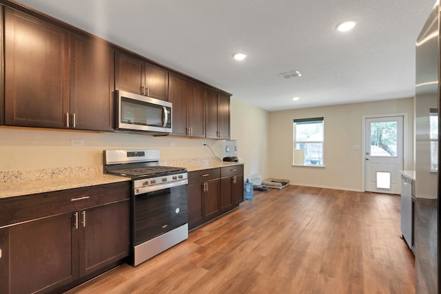 kitchen with light hardwood / wood-style floors, dark brown cabinetry, and stainless steel appliances