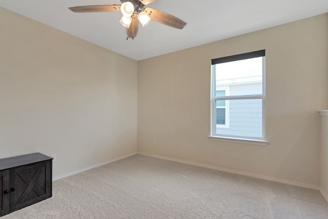 carpeted spare room with ceiling fan