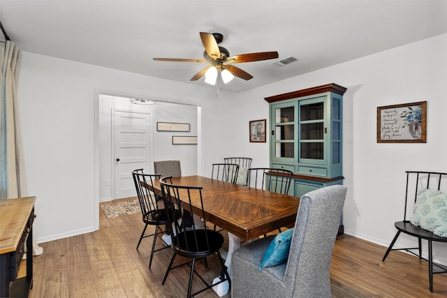 dining space with wood-type flooring and ceiling fan