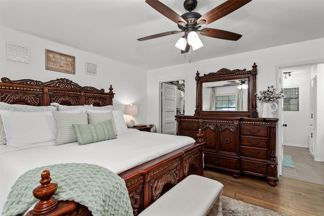 bedroom featuring hardwood / wood-style floors, ceiling fan, and a spacious closet