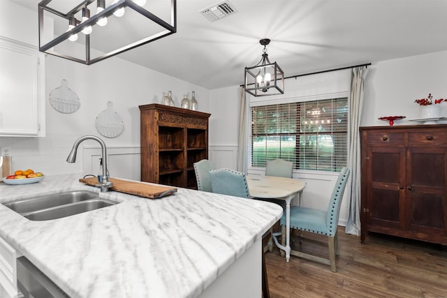 kitchen featuring sink, an inviting chandelier, dark hardwood / wood-style floors, backsplash, and pendant lighting