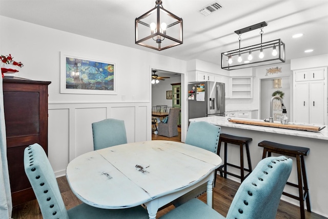 dining space featuring dark hardwood / wood-style floors, ceiling fan, and sink