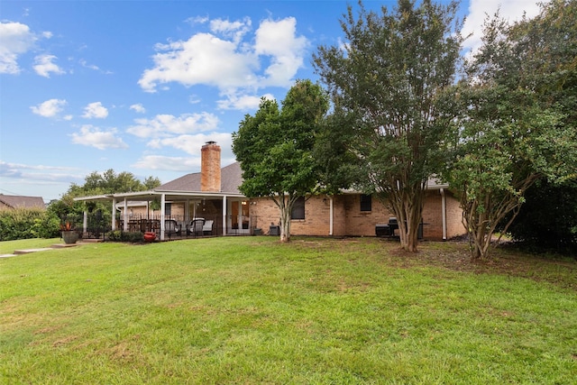 rear view of house featuring a yard