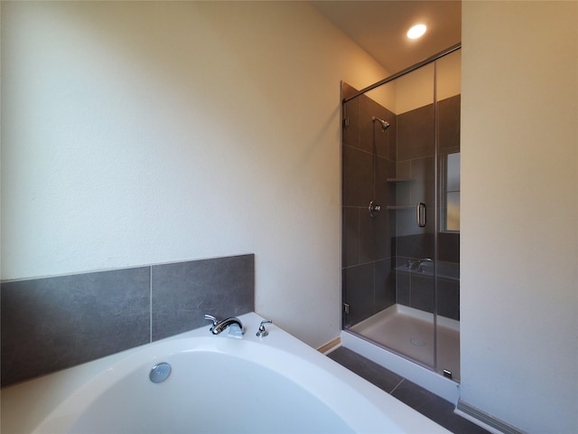 bathroom featuring a stall shower and a garden tub