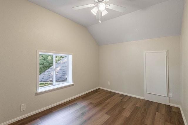 spare room featuring vaulted ceiling, ceiling fan, and dark hardwood / wood-style floors