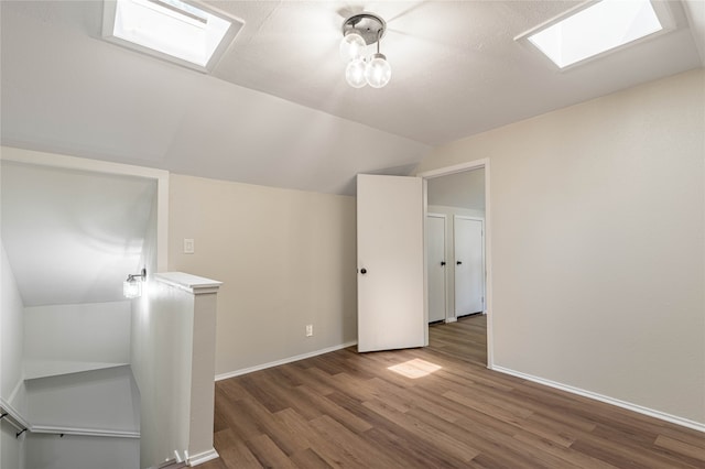 bonus room with hardwood / wood-style floors and lofted ceiling with skylight