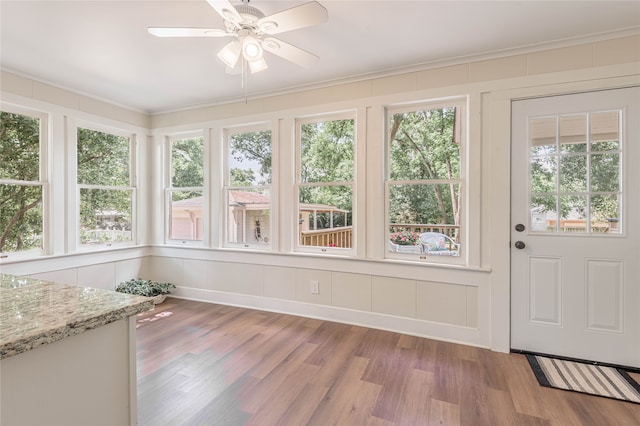 unfurnished sunroom featuring ceiling fan