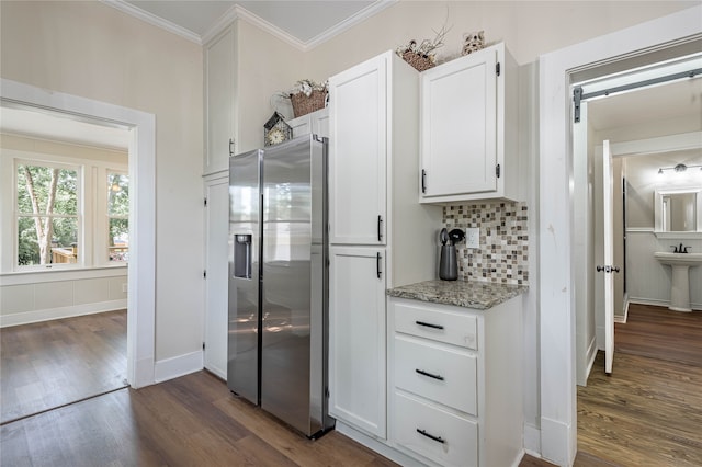 kitchen with dark hardwood / wood-style floors, tasteful backsplash, crown molding, white cabinetry, and stainless steel fridge