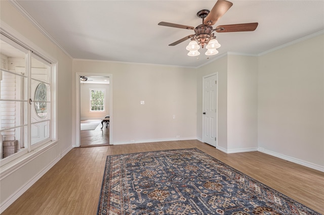 empty room with ornamental molding, wood-type flooring, and ceiling fan