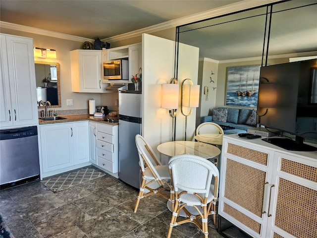 kitchen featuring white cabinets, appliances with stainless steel finishes, ornamental molding, and sink