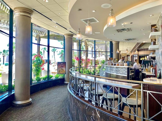 reception area featuring decorative columns and bar