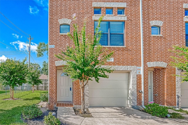 townhome / multi-family property featuring a garage and a front yard