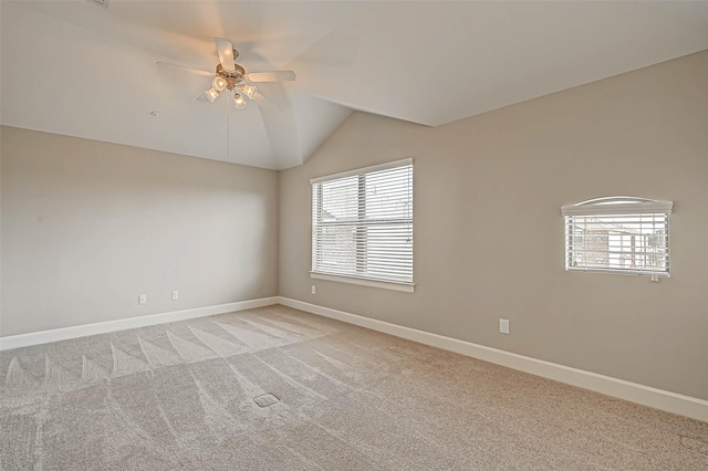 carpeted spare room with ceiling fan and vaulted ceiling