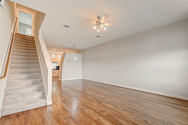 unfurnished living room with hardwood / wood-style floors and ceiling fan