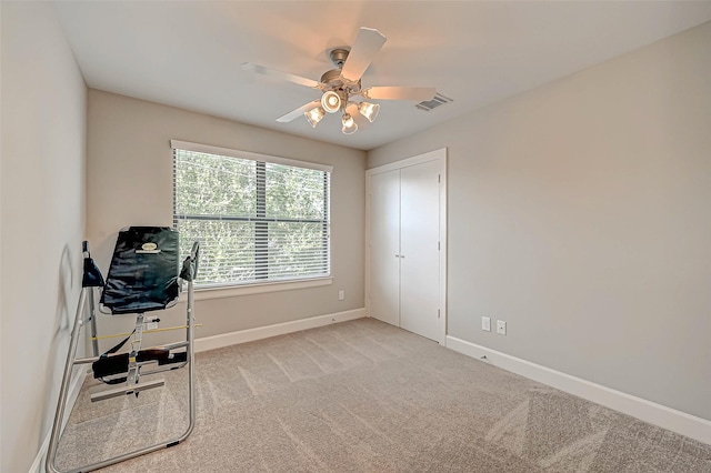 unfurnished office featuring light carpet and ceiling fan