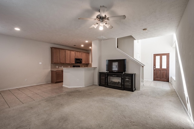 unfurnished living room featuring ceiling fan and light tile patterned floors