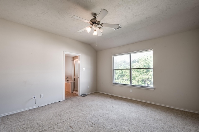 spare room with ceiling fan, light colored carpet, a textured ceiling, and vaulted ceiling