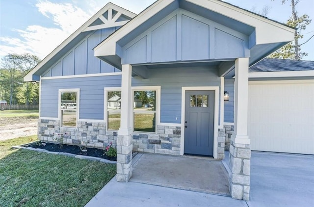 doorway to property featuring a garage and a lawn