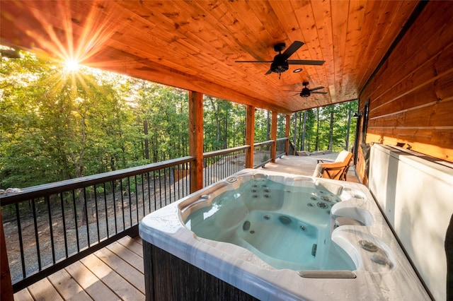 wooden deck with a ceiling fan and a hot tub