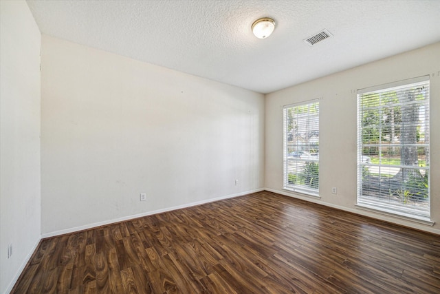 unfurnished room featuring dark hardwood / wood-style floors and a textured ceiling