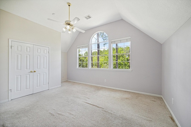 additional living space with ceiling fan, light colored carpet, and vaulted ceiling