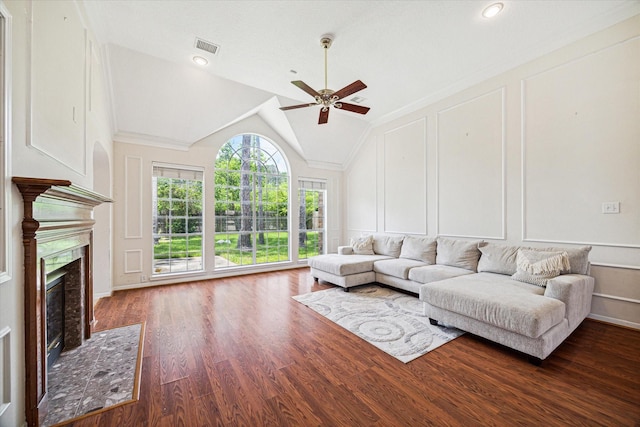 living room featuring ceiling fan, crown molding, dark wood-type flooring, and vaulted ceiling