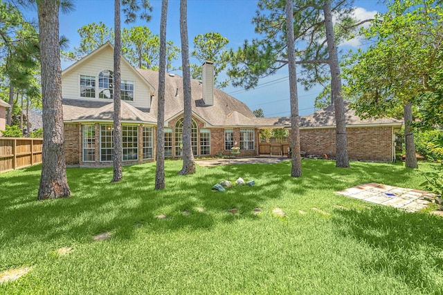 rear view of property featuring a yard