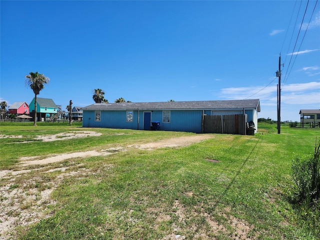 rear view of house with a yard and fence