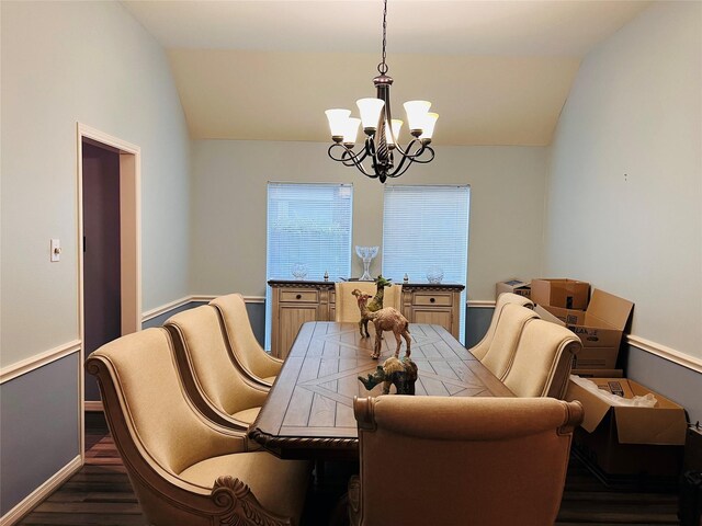 dining area with dark hardwood / wood-style floors, lofted ceiling, and an inviting chandelier