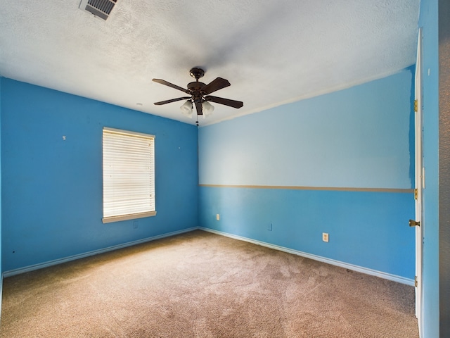 spare room featuring carpet flooring, ceiling fan, and a textured ceiling