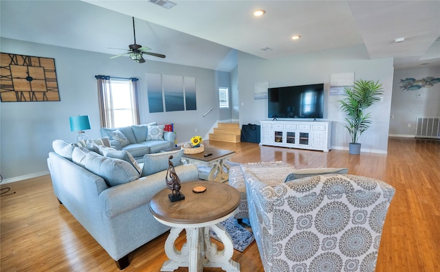 living room with vaulted ceiling, ceiling fan, and light wood-type flooring