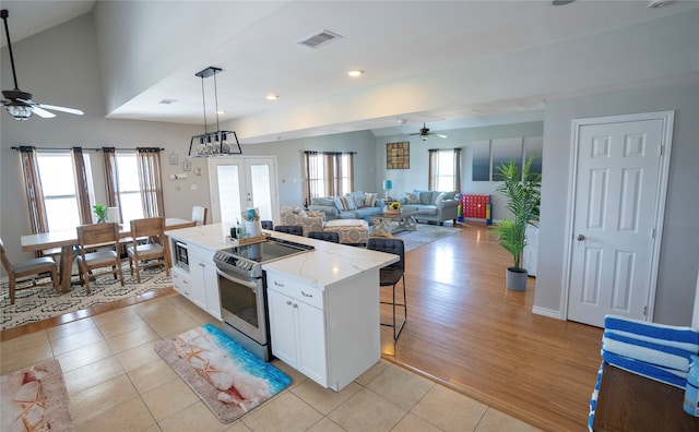 kitchen with ceiling fan, light tile floors, white cabinets, and stainless steel electric range