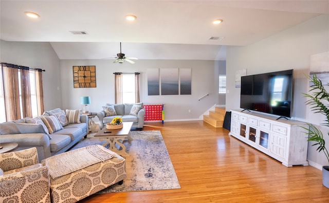 living room with light hardwood / wood-style floors, lofted ceiling, and ceiling fan