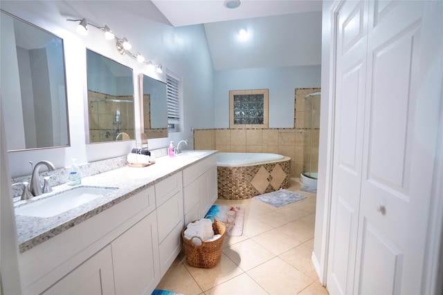 full bathroom with double vanity, shower with separate bathtub, vaulted ceiling, tile floors, and toilet