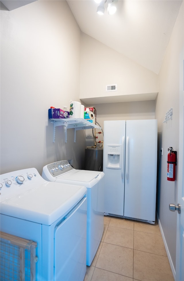 washroom featuring water heater, independent washer and dryer, and light tile floors