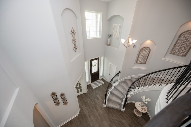 foyer entrance with a chandelier, dark hardwood / wood-style floors, and a high ceiling