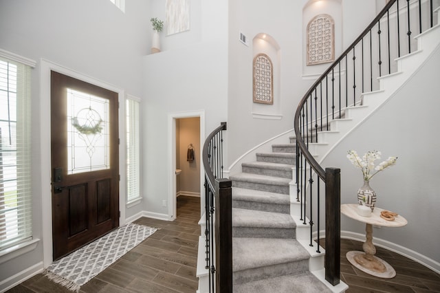 foyer entrance featuring dark wood-type flooring and a high ceiling