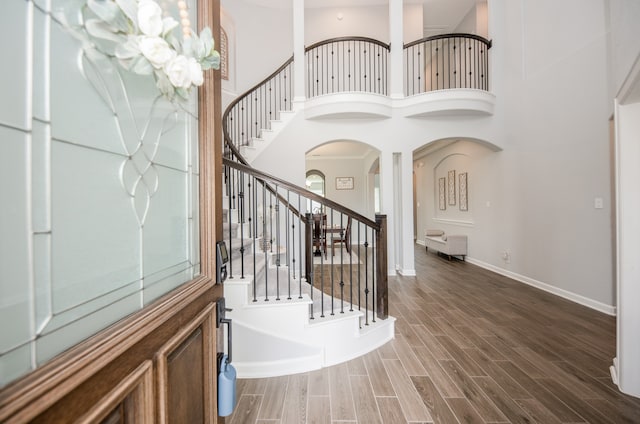 entryway with a towering ceiling and hardwood / wood-style floors