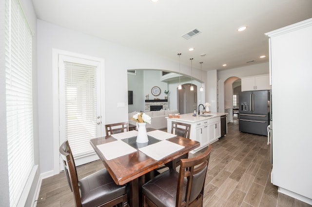 dining area with light hardwood / wood-style flooring, a fireplace, and sink