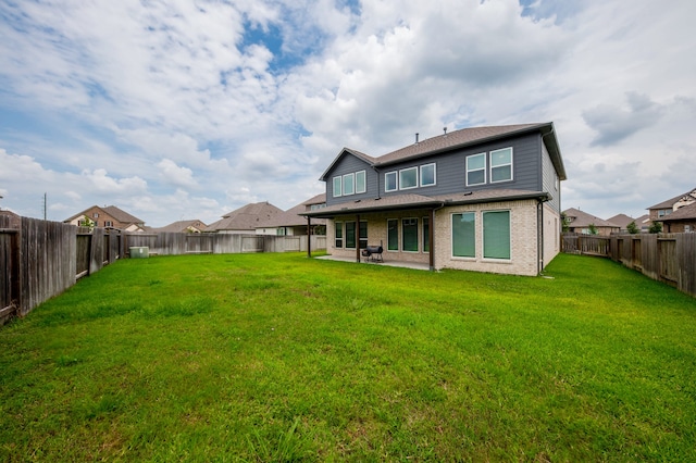 rear view of property featuring a patio and a yard