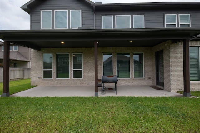 back of property featuring a patio and a yard