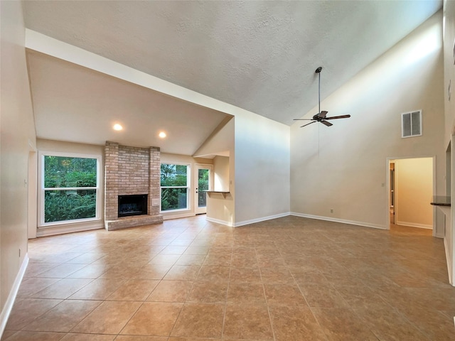 unfurnished living room featuring high vaulted ceiling, ceiling fan, light tile patterned floors, a textured ceiling, and a fireplace