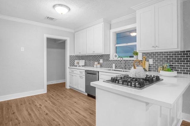 kitchen with white cabinetry, stainless steel appliances, tasteful backsplash, and sink