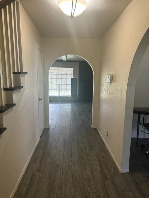 corridor featuring dark hardwood / wood-style floors and a textured ceiling