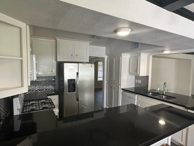 kitchen featuring white cabinetry, white appliances, sink, and tasteful backsplash