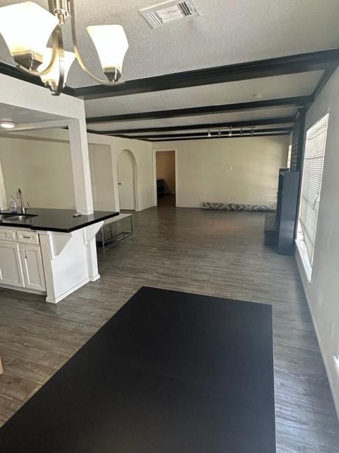 interior space featuring white cabinets, beam ceiling, dark hardwood / wood-style flooring, and sink