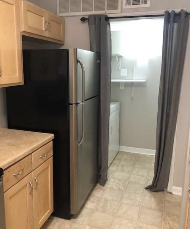 kitchen featuring stainless steel refrigerator, washer / clothes dryer, and light brown cabinets