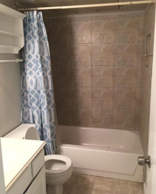 full bathroom featuring tile patterned flooring, vanity, toilet, and shower / bathtub combination with curtain