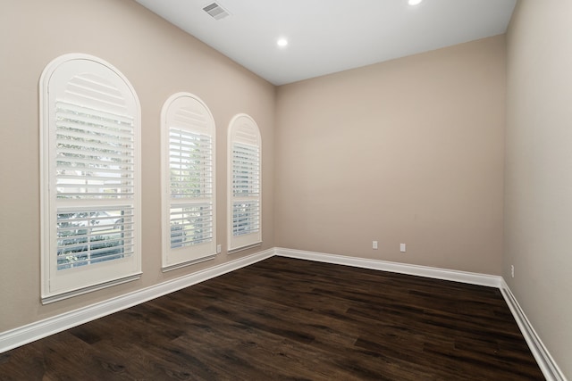 unfurnished room with dark hardwood / wood-style flooring