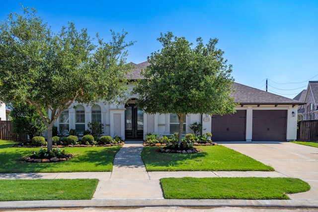 obstructed view of property featuring a garage and a front lawn